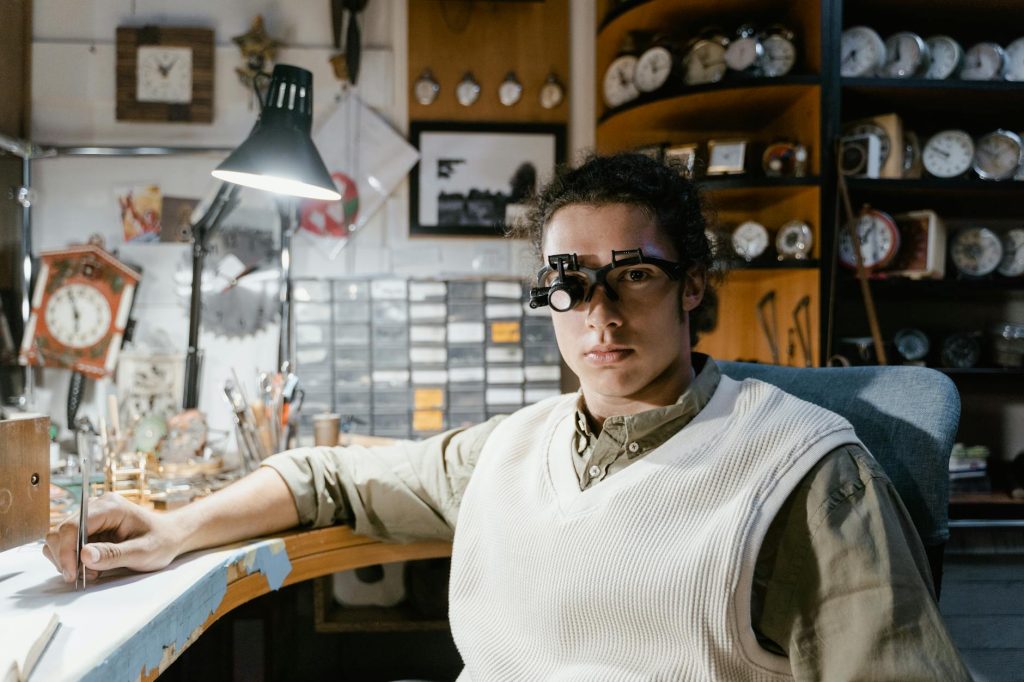 A trusted professional watchmaker smiling in a well-equipped repair workshop, representing OchkoRepair's experienced team